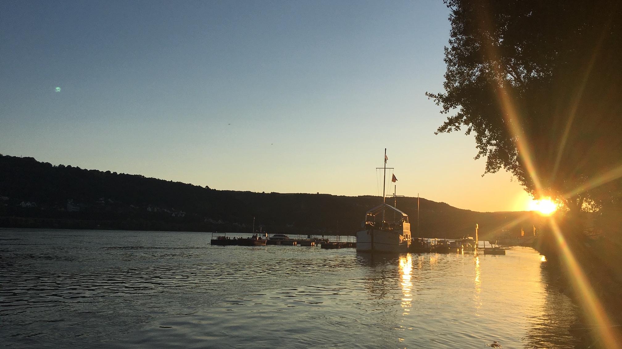 Innehalten und den Sonnenuntergang am Rheinufer bestaunen.